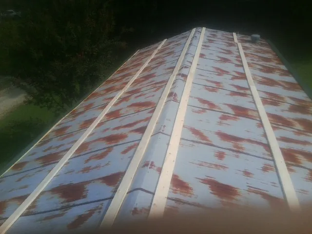 Rusted metal roof panels with new wood purlins before replacement — Storm Damage Roof Repair in Thiells by Roofing Brothers