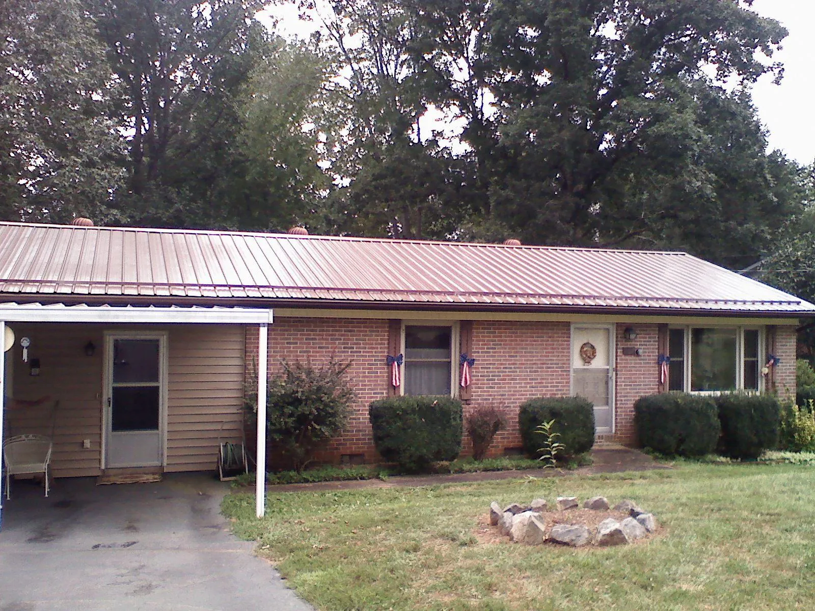 Bronze metal roof and carport on a brick ranch home — Roof Repair work by our crew in Thiells